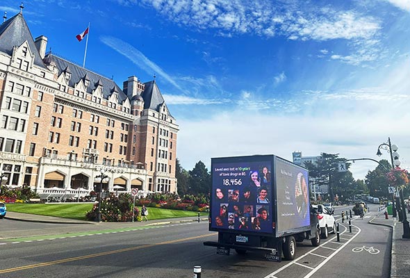 Grow More LED truck displaying remembrance portraits during an overdose awareness campaign in Victoria